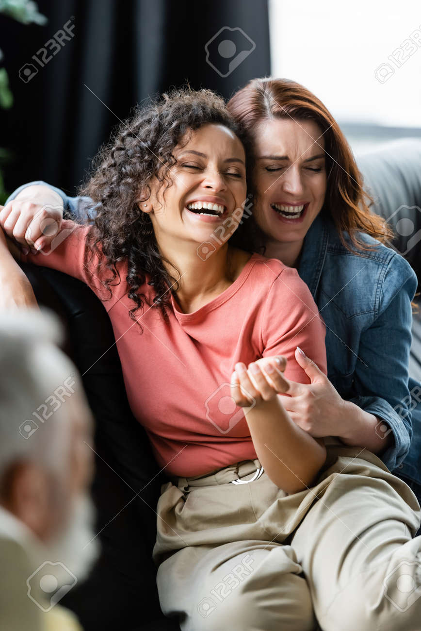 Couple De Lesbiennes Multiethnique Excité Aux Yeux Fermés Riant Près D'un  Psychologue Flou Dans La Salle De Consultation Banque D'Images et Photos  Libres De Droits. Image 179107104