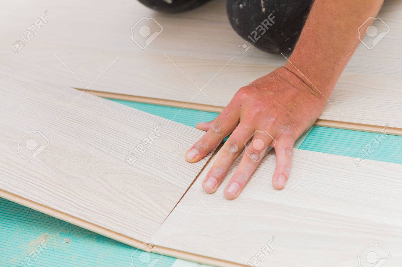 Handyman S Dusty Hands Laying Down Laminate Wood Flooring Boards Handyman S Dusty Hands Laying Down Laminate Wood Flooring Boards Mounting Them Together With Great Care
