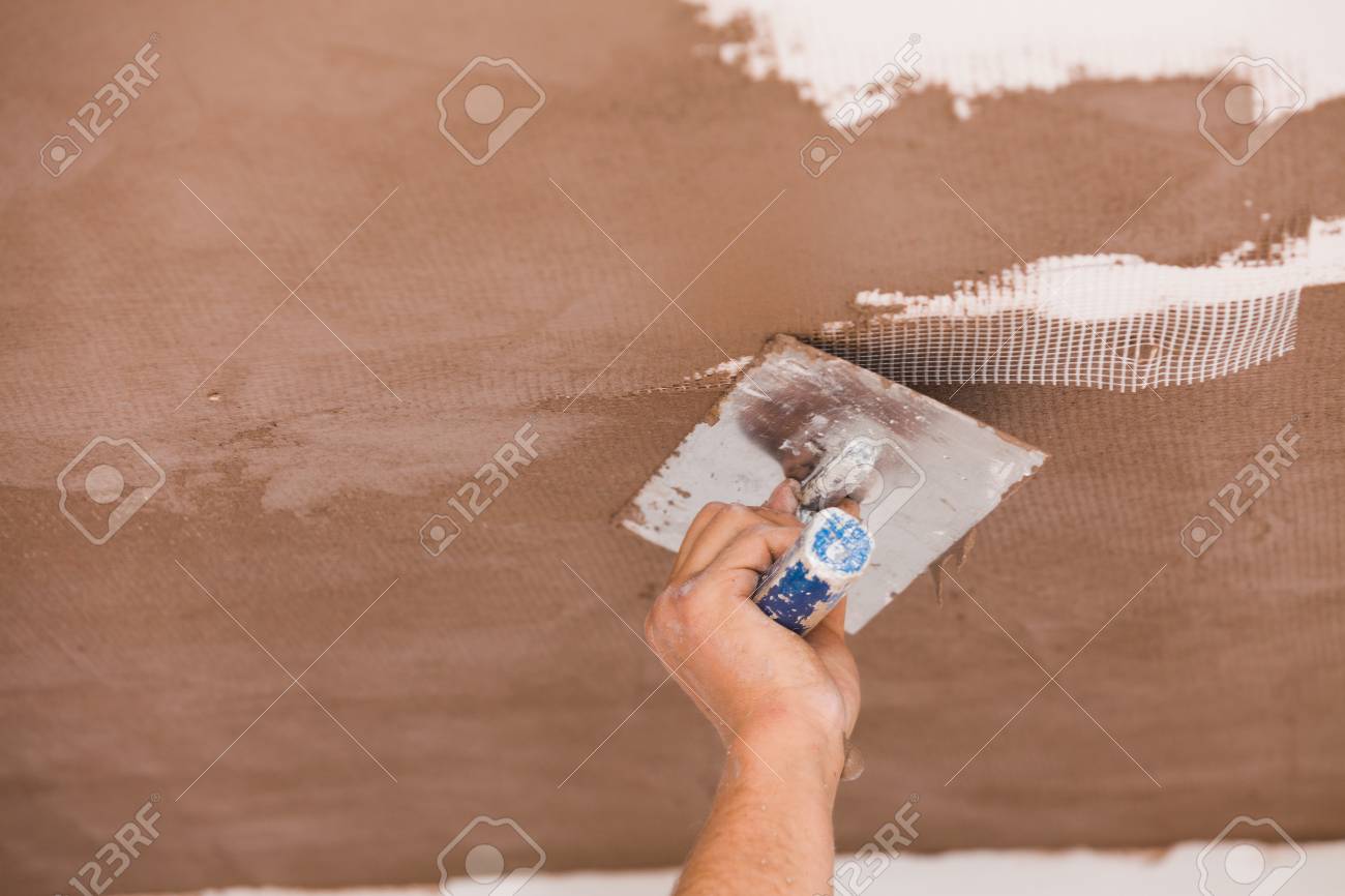Construction Worker Skim Coating The Ceiling After The Application