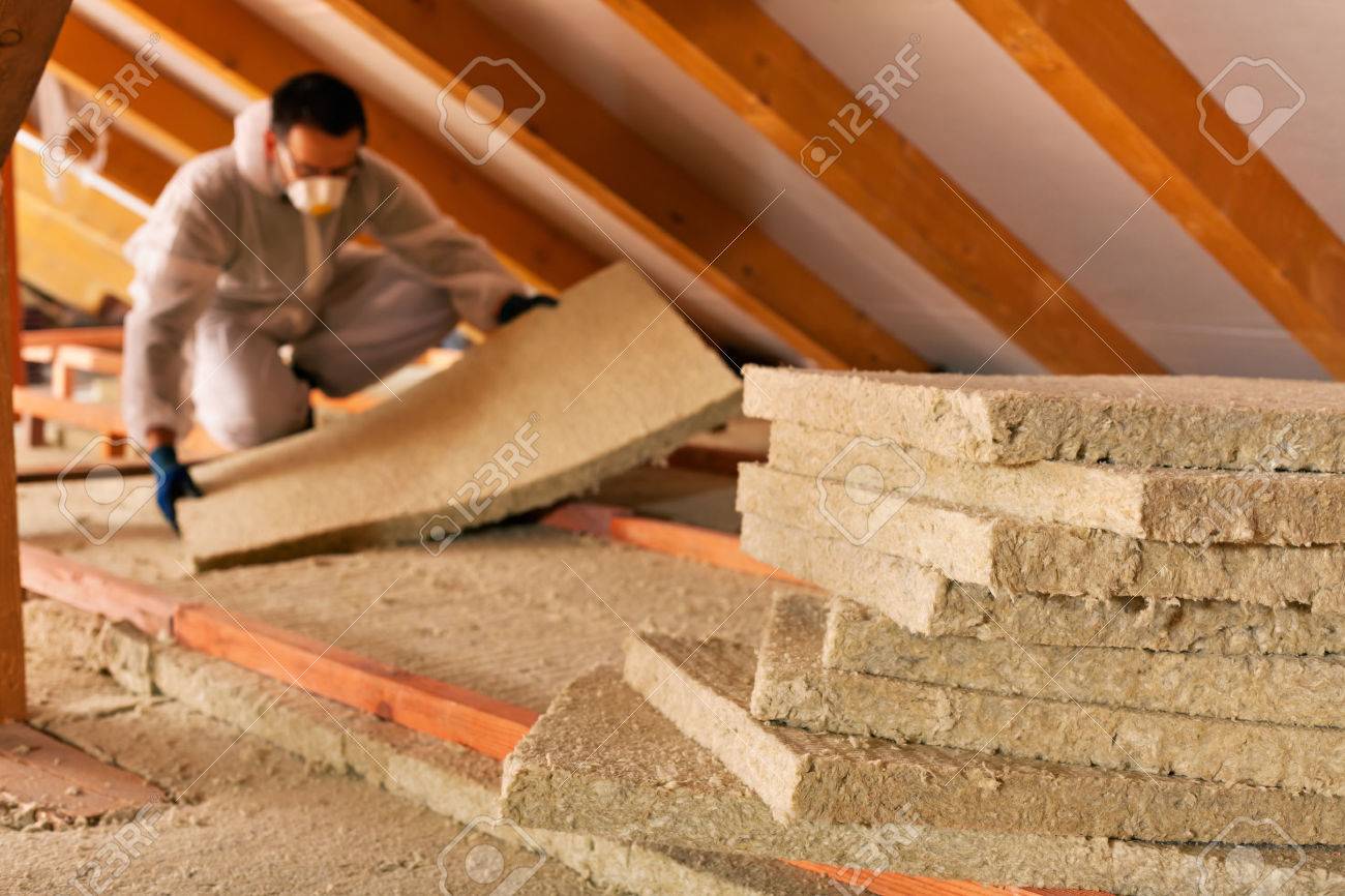 Man installing thermal insulation layer under the roof - using mineral wool panels - 34051671 Man installing thermal insulation layer under the roof - using mineral wool panels - 34051671