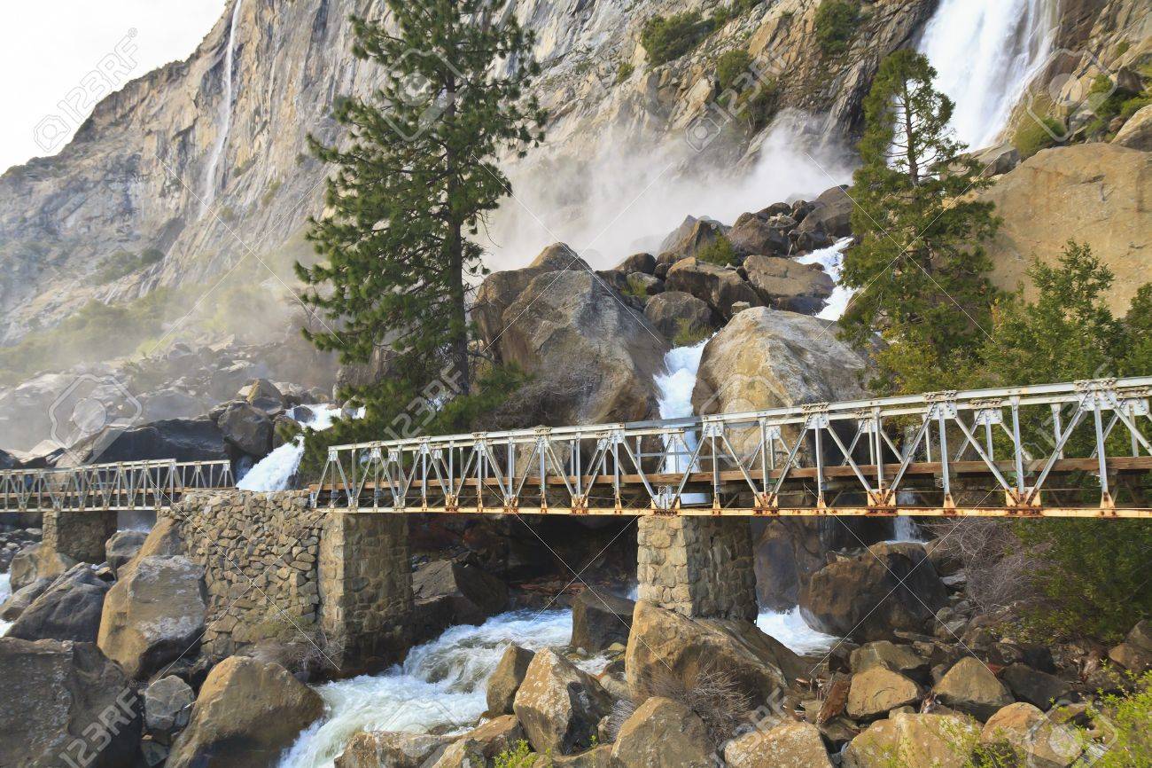 Misty Wapama Falls divides and spills under a footbridge and between boulders before falling into the Hetch Hetchy Reservoir in Yosemite National Park, California - 13438786 Misty Wapama Falls divides and spills under a footbridge and between boulders before falling into the Hetch Hetchy Reservoir in Yosemite National Park, California - 13438786