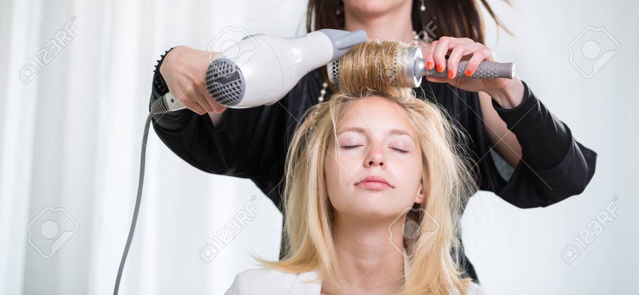 pretty young woman having her hair done by a professional hairstylist stock photo 37882333