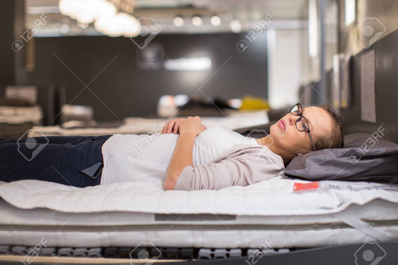 Pretty, young woman choosing the right furniture for her apartment in a modern home furnishings store (color toned image; shallow DOF) - 50640374 Pretty, young woman choosing the right furniture for her apartment in a modern home furnishings store (color toned image; shallow DOF) - 50640374