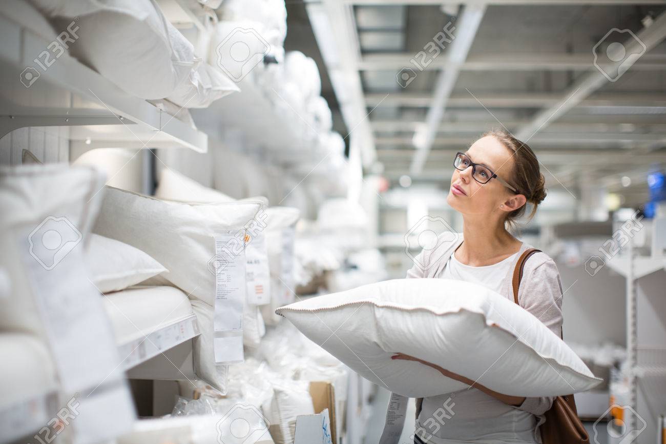 Pretty, young woman choosing the right pillow for her bed in a modern home furnishings store (color toned image; shallow DOF) - 50699189 Pretty, young woman choosing the right pillow for her bed in a modern home furnishings store (color toned image; shallow DOF) - 50699189