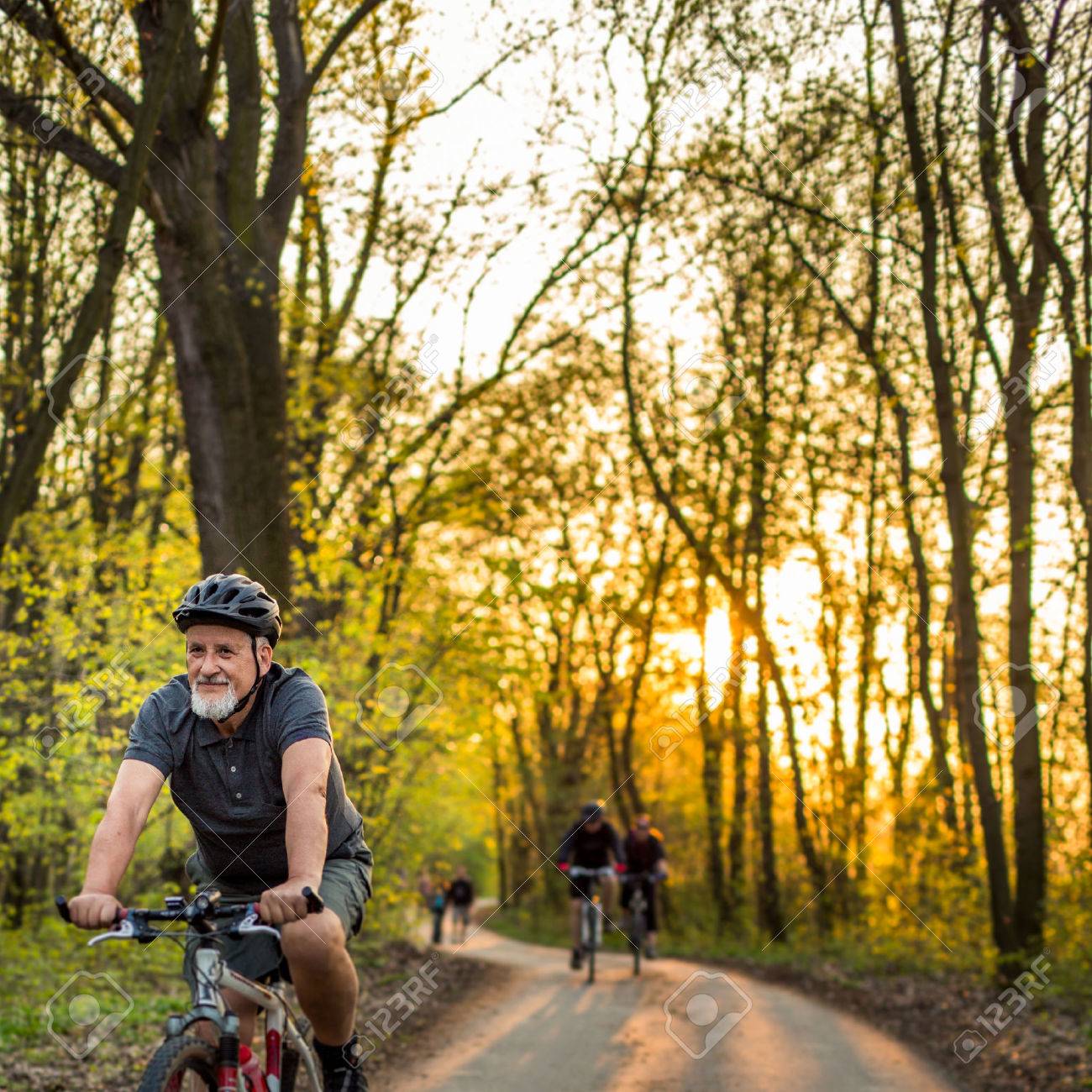 Senior man on his mountain bike outdoors (shallow DOF; color toned image) - 54568150 Senior man on his mountain bike outdoors (shallow DOF; color toned image) - 54568150
