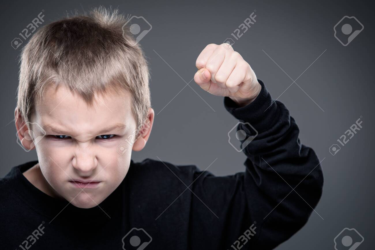 Loads of aggression in a little boy - education concept hinting behavioral problems in young children (shallow DOF) - little boy with hands clenched into fists about to punch someone - 123494473 Loads of aggression in a little boy - education concept hinting behavioral problems in young children (shallow DOF) - little boy with hands clenched into fists about to punch someone - 123494473