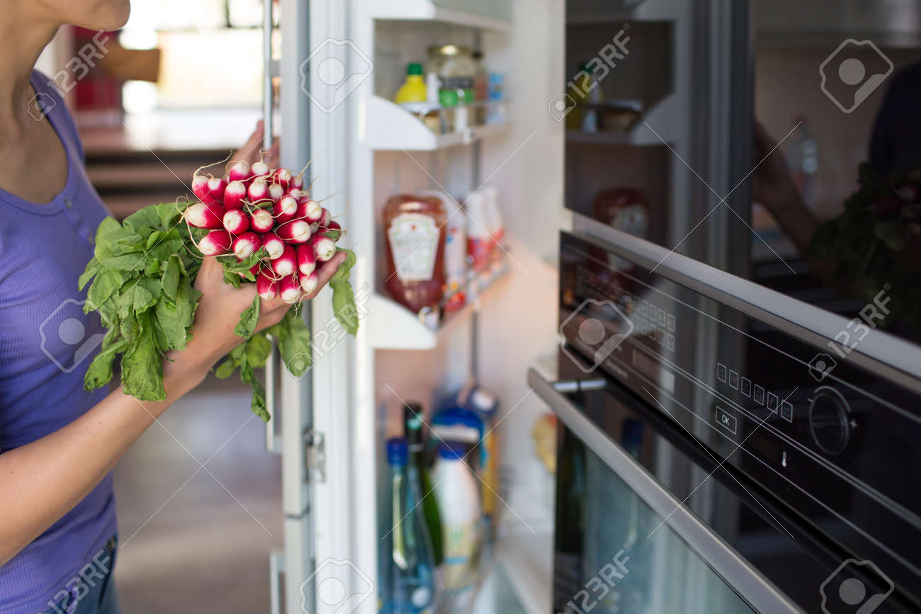 Pretty, young woman taking fresh vegetables from her fridge - being on a gluten free vegan diet does not seem to be a problem for her (shallow DOF; color toned image) - 171623449 Pretty, young woman taking fresh vegetables from her fridge - being on a gluten free vegan diet does not seem to be a problem for her (shallow DOF; color toned image) - 171623449
