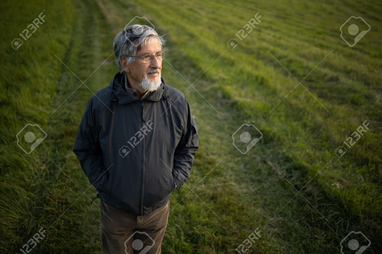 Senior man enjoying the outdoors, hiking, walking through lovely nature - 171623506 Senior man enjoying the outdoors, hiking, walking through lovely nature - 171623506