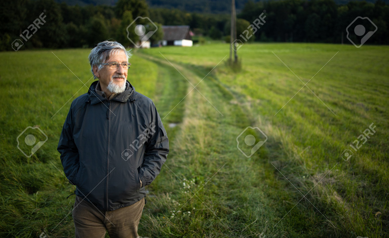 Senior man enjoying the outdoors, hiking, walking through lovely nature - 171623518 Senior man enjoying the outdoors, hiking, walking through lovely nature - 171623518