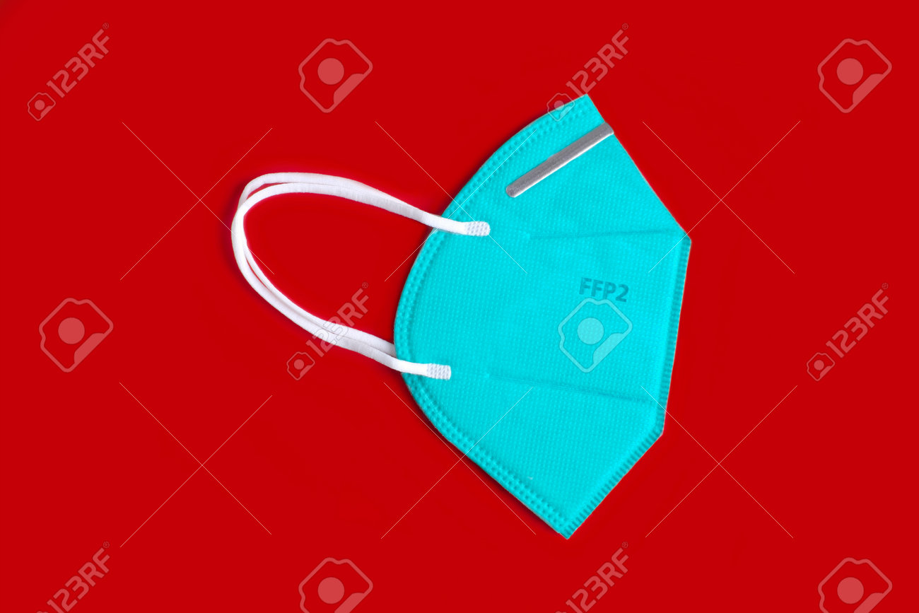 Side view of green FFP2 n95 protective face mask, virus prevention. Isolated on red background. - 163977359 Side view of green FFP2 n95 protective face mask, virus prevention. Isolated on red background. - 163977359