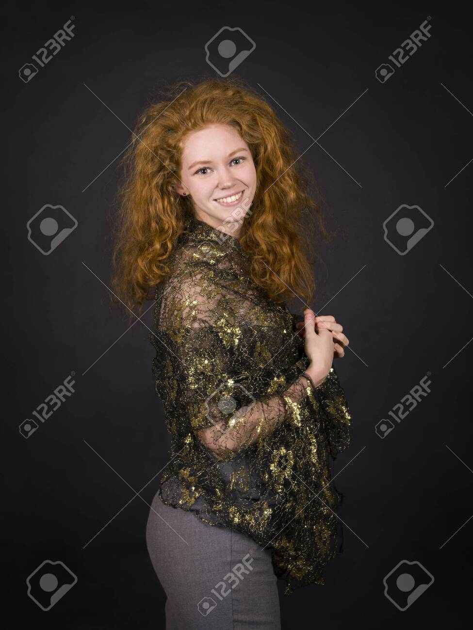 Emotional, red-haired girl in a brocade blouse posing. Studio shooting on a dark background. - 124488667 Emotional, red-haired girl in a brocade blouse posing. Studio shooting on a dark background. - 124488667