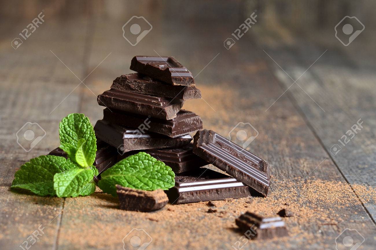 Stack of chocolate slices with mint leaf on a wooden table. - 35649126 Stack of chocolate slices with mint leaf on a wooden table. - 35649126