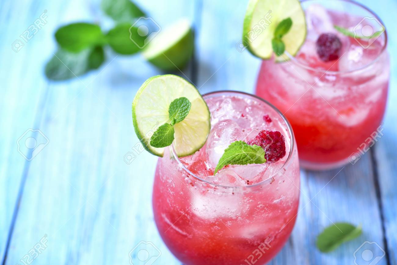 Raspberry lemonade with lime in a glass on a blue wooden background. - 51622103 Raspberry lemonade with lime in a glass on a blue wooden background. - 51622103