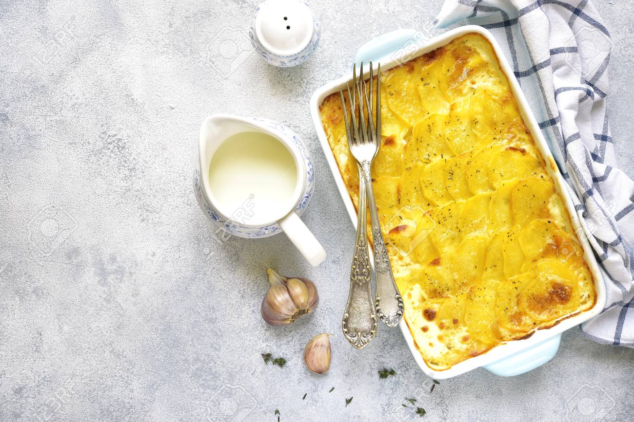 Potato gratin in a blue baking dish on a light background.Top view. - 71105989 Potato gratin in a blue baking dish on a light background.Top view. - 71105989