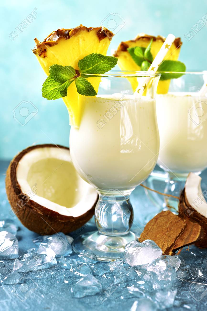 Traditional caribbean cocktail pina colada in a glasses on a blue slate,stone or concrete background. - 90005334 Traditional caribbean cocktail pina colada in a glasses on a blue slate,stone or concrete background. - 90005334