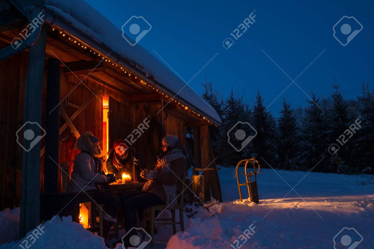 夕方の冬のコテージの友人は 雪の田園地帯でホットド リンクを楽しむ の写真素材 画像素材 Image