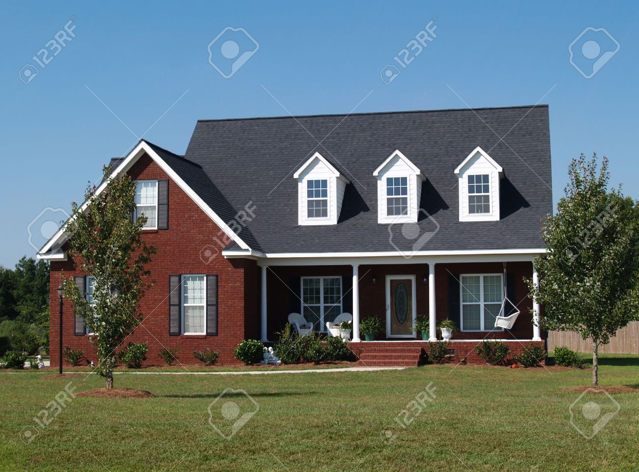 Two story brick residential home with porch swing. - 5580909 Two story brick residential home with porch swing. - 5580909