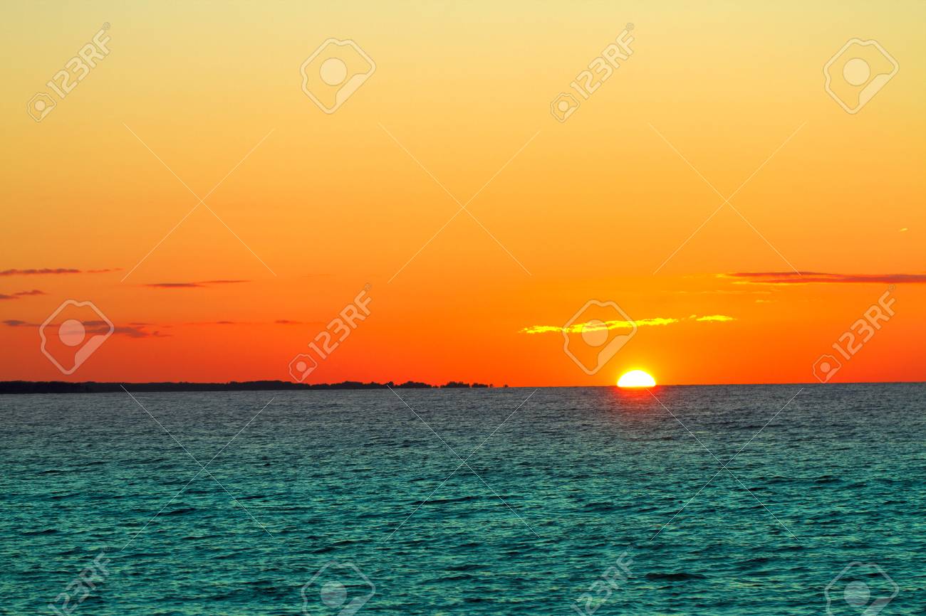 海に沈む夕日 赤とオレンジの太陽と青い海 の写真素材 画像素材 Image