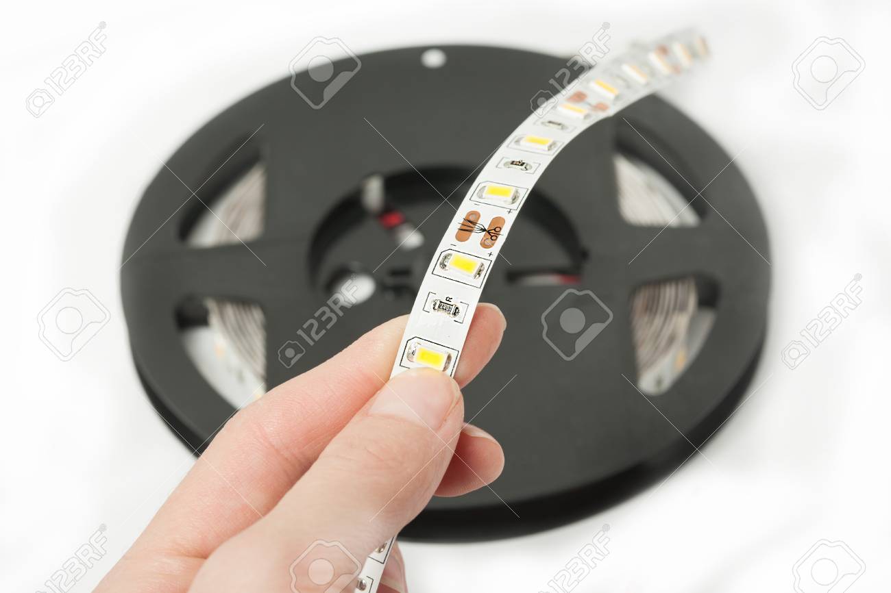 Plastikrolle Mit Led Streifen Fur Das Beleuchten Des Raumes Led Beleuchtet Das Band Das Auf Weissem Hintergrund Lokalisiert Wird Die Hand Halt Ein Stuck Klebeband Lizenzfreie Fotos Bilder Und Stock Fotografie Image