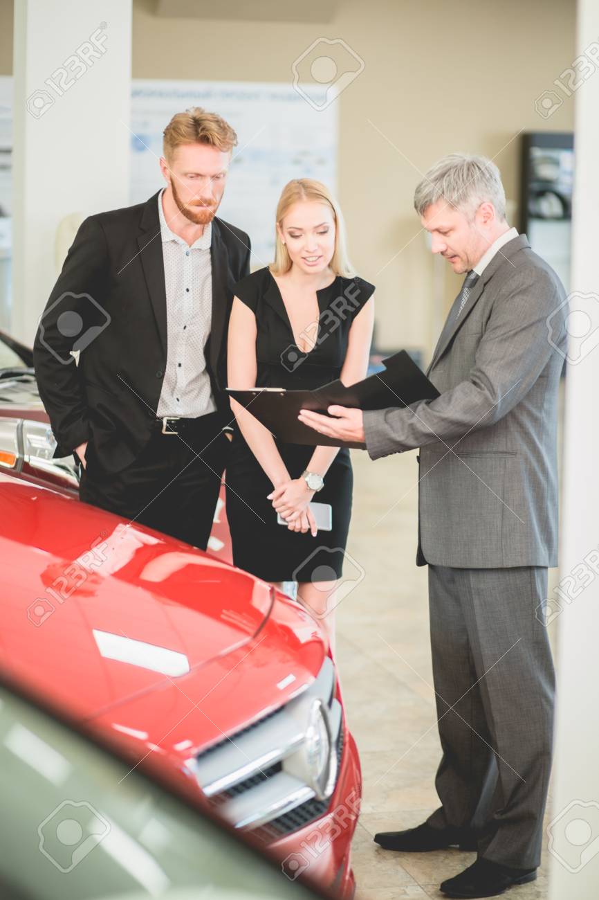 家族カップル車両ディーラーと話して 新しい車を買います 若い男性と女性に車を販売する自動車販売店での営業部長 の写真素材 画像素材 Image 90580262