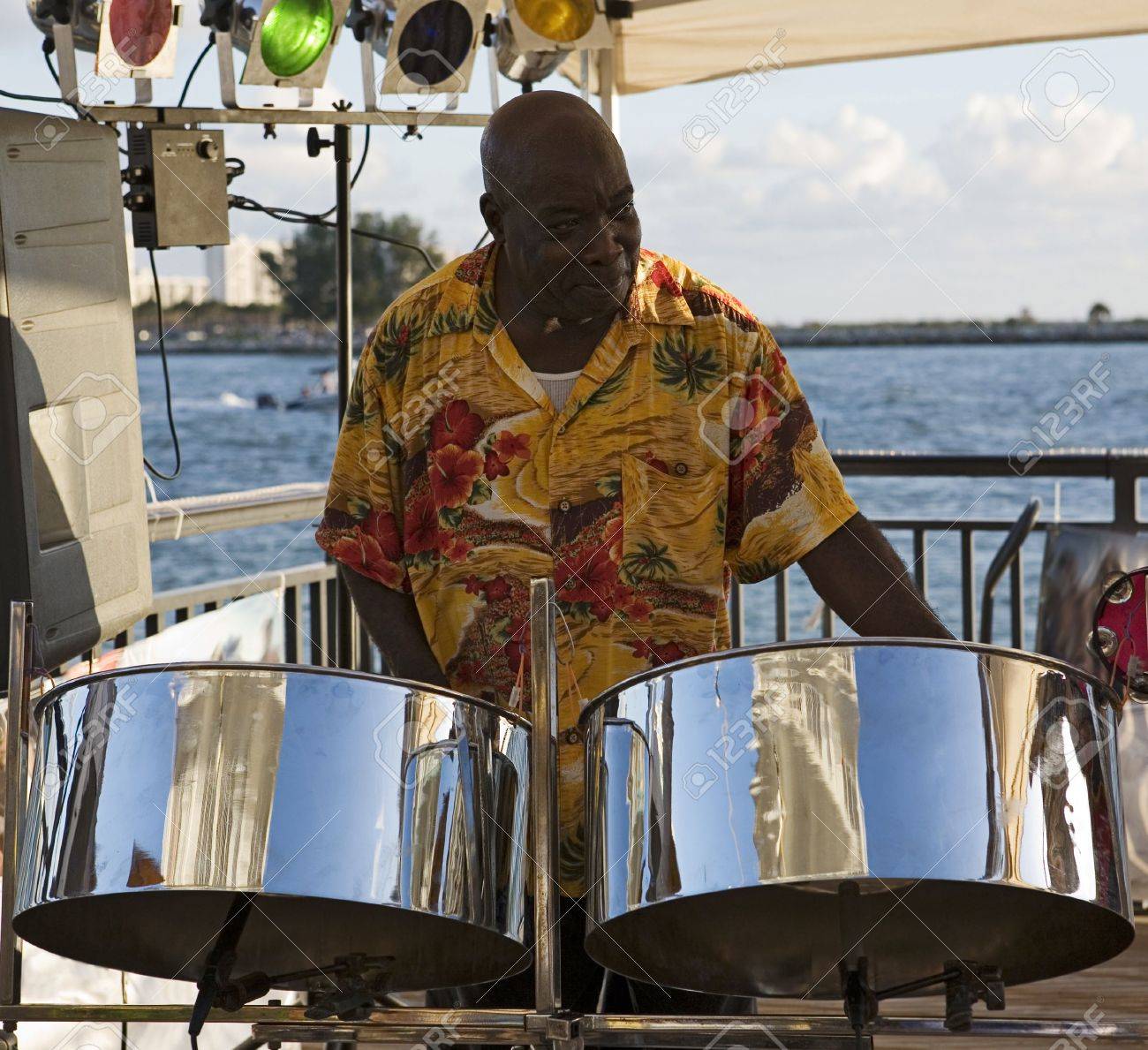 Фото со стока - A caribbean musician playing steel drums with the ocean in ...