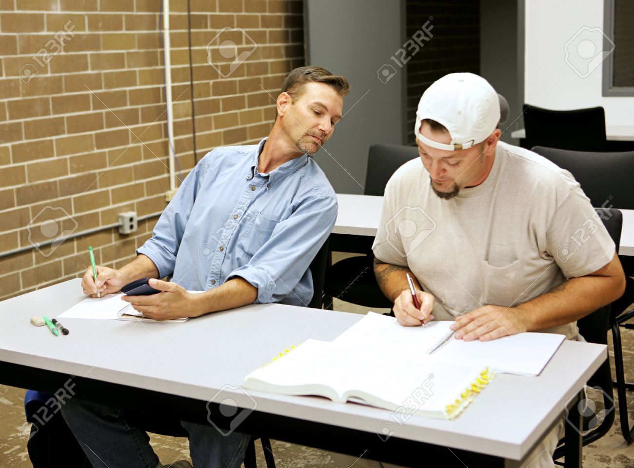 An Adult Education Student Cheating On Exams By Looking Over Another Students Shoulder Stock Photo An Adult Education Student Cheating On Exams By Looking Over Another Students Shoulder Stock Photo