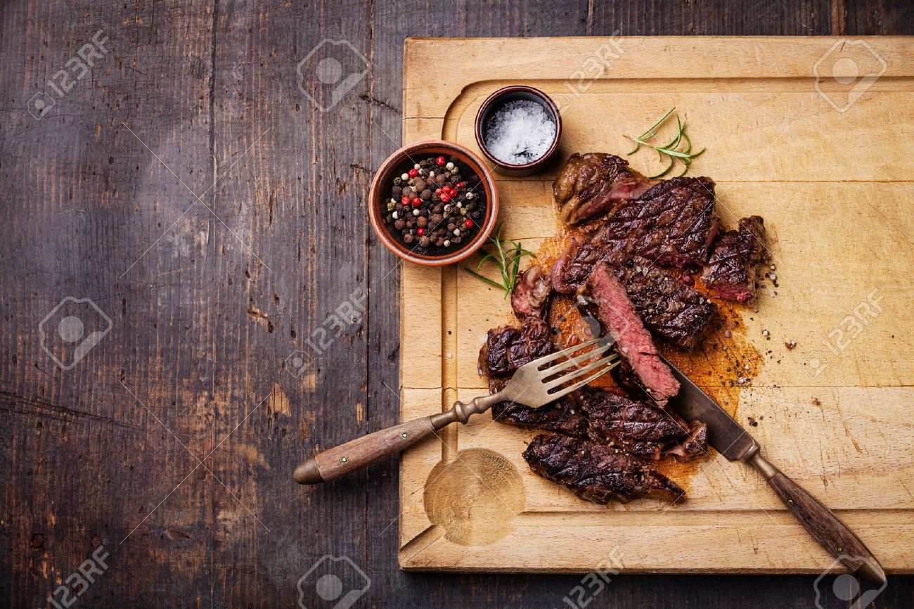 中珍しい焼き牛ステーキ リブロース塩とコショウを肉暗い背景の木のまな板の上スライス の写真素材 画像素材 Image