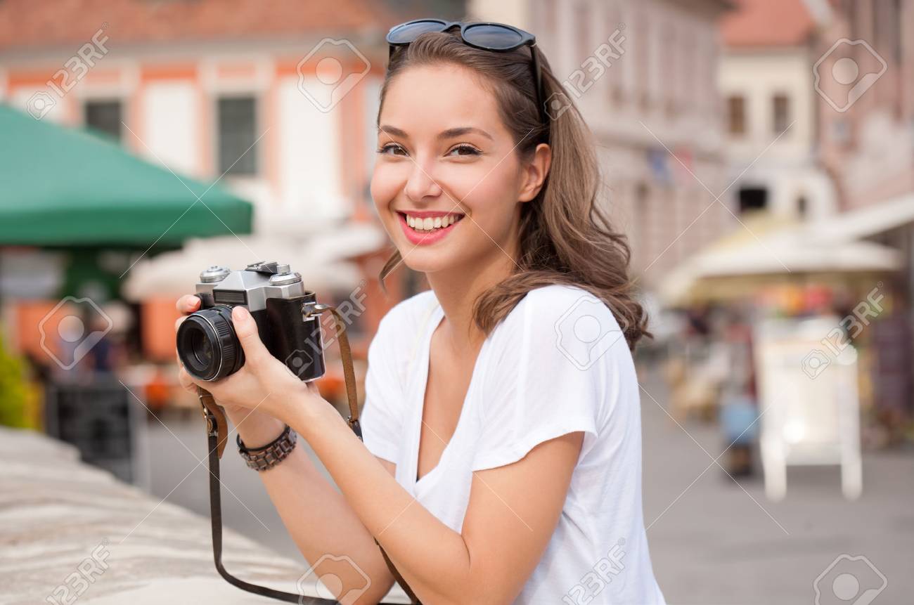 Portrait of a young brunette tourist woman taking photos. - 46512747 Portrait of a young brunette tourist woman taking photos. - 46512747