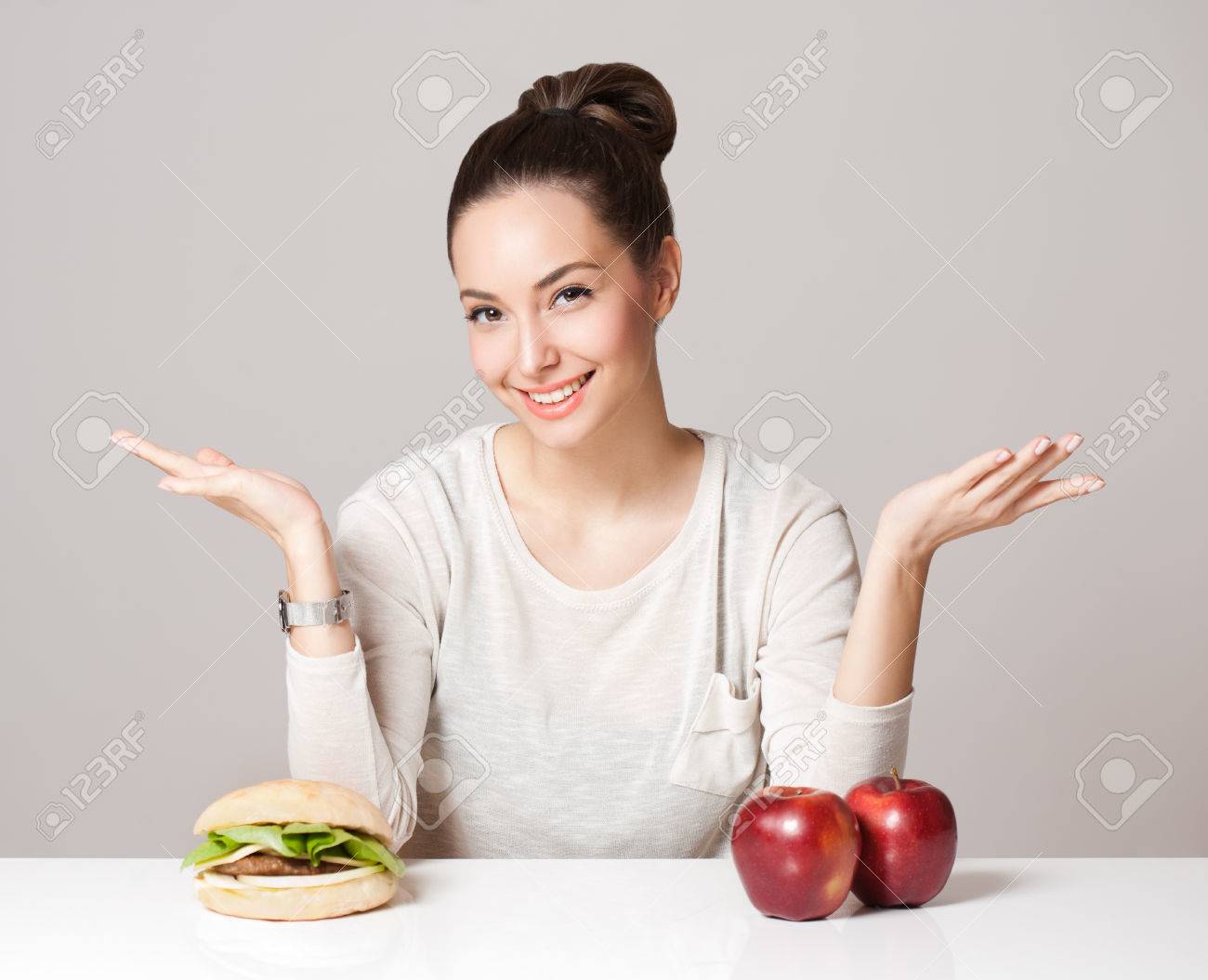 Portrait of a gorgeous young brunette woman showing diet food choices. - 53682846 Portrait of a gorgeous young brunette woman showing diet food choices. - 53682846