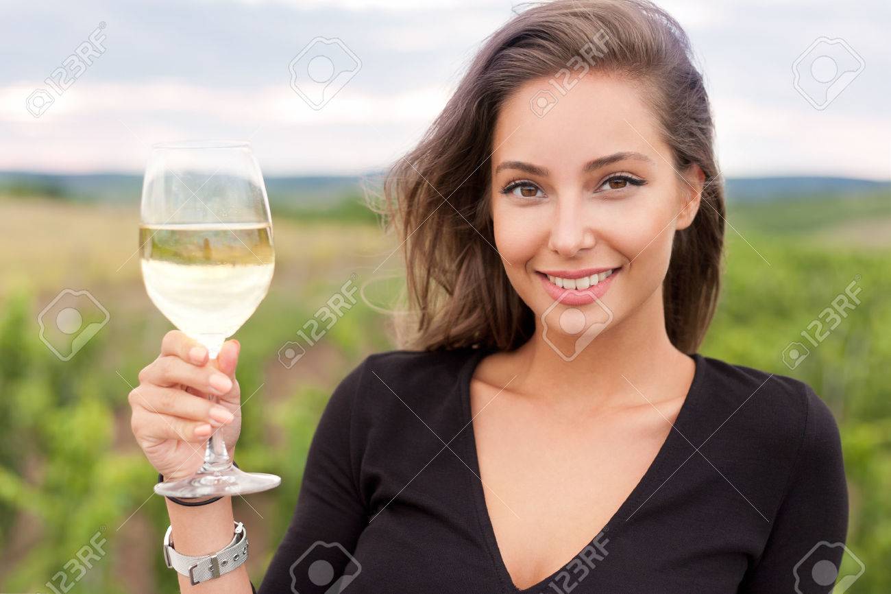 Outdoors portrait of a beautiful wine tasting tourist woman. - 60770524 Outdoors portrait of a beautiful wine tasting tourist woman. - 60770524