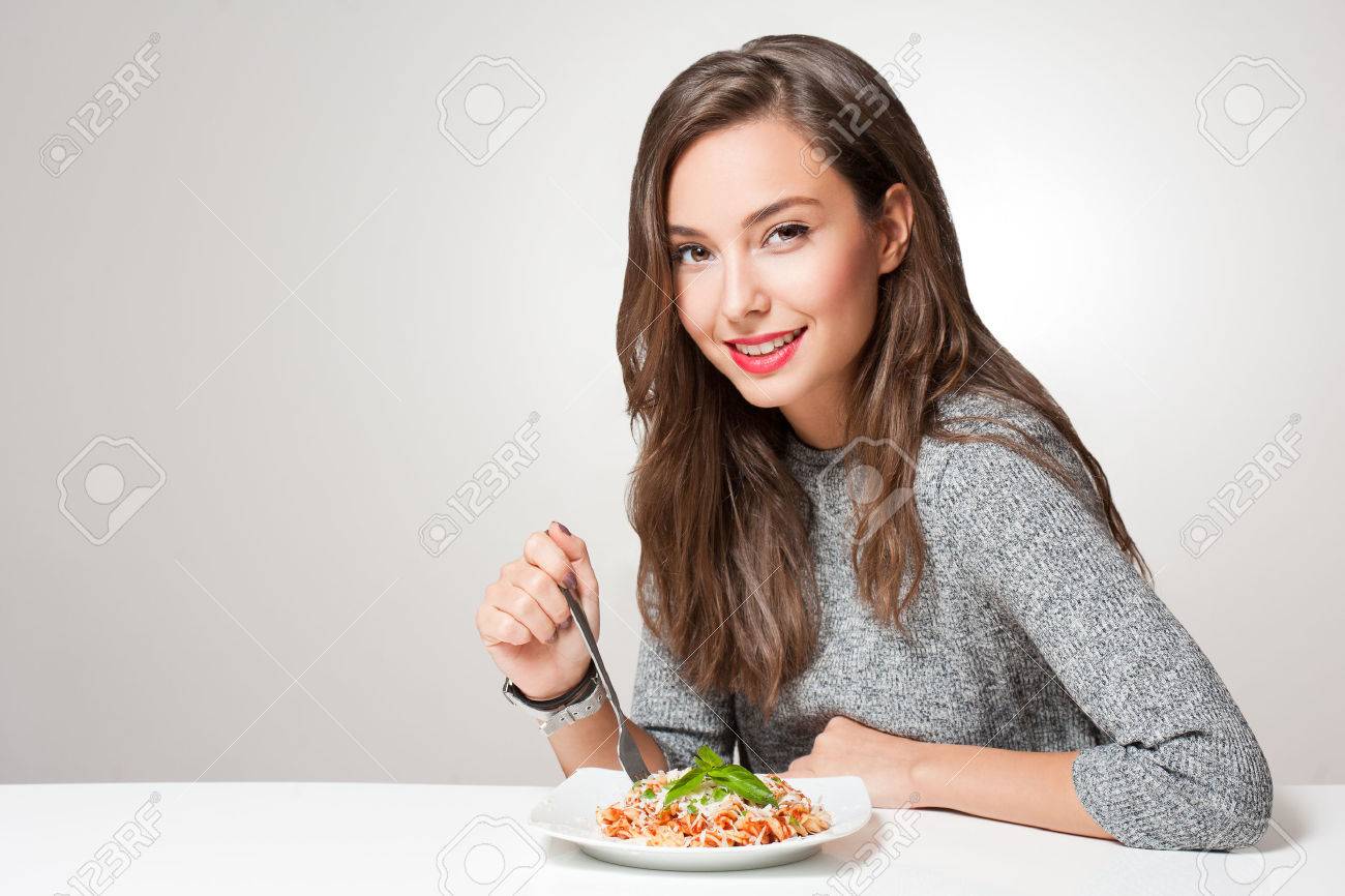 Beautiful young brunette woman eating Italian pasta. - 66081700 Beautiful young brunette woman eating Italian pasta. - 66081700