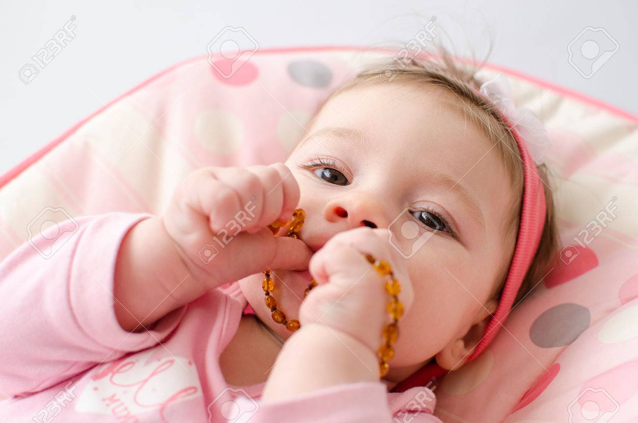 baby chewing on amber necklace