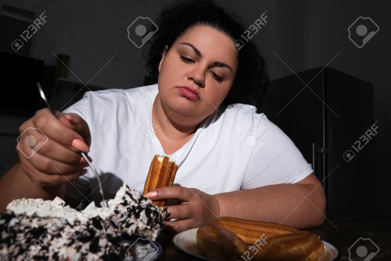 https://previews.123rf.com/images/liudmilachernetska/liudmilachernetska2301/liudmilachernetska230115022/196547450-depressed-overweight-woman-eating-sweets-in-kitchen-at-night.jpg