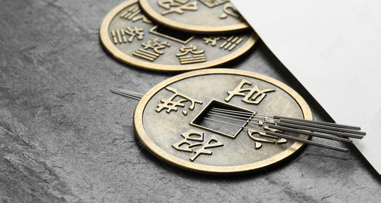 鍼治療の針、古代のコイン、灰色の質感のテーブルのクローズアップに文字が描かれた紙の写真素材・画像素材 Image 228875500
