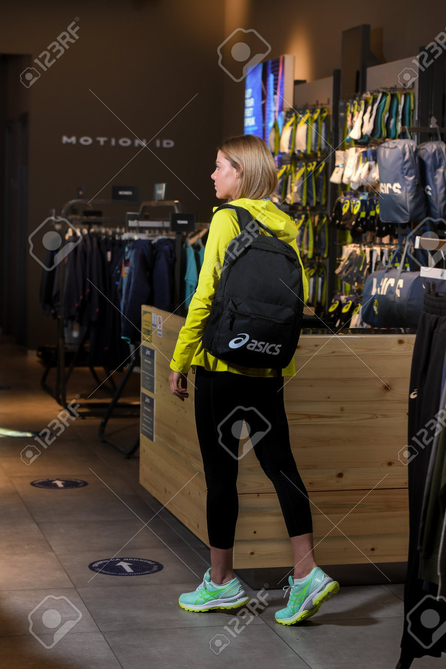 Skopje, North Macedonia - March 12, 2021: Asics store in Skopje, North Macedonia. Girl photo model wearing sports tracksuits and sneakers ASICS GEL, carrying a sports backpack on her shoulder - 166321432 Skopje, North Macedonia - March 12, 2021: Asics store in Skopje, North Macedonia. Girl photo model wearing sports tracksuits and sneakers ASICS GEL, carrying a sports backpack on her shoulder - 166321432