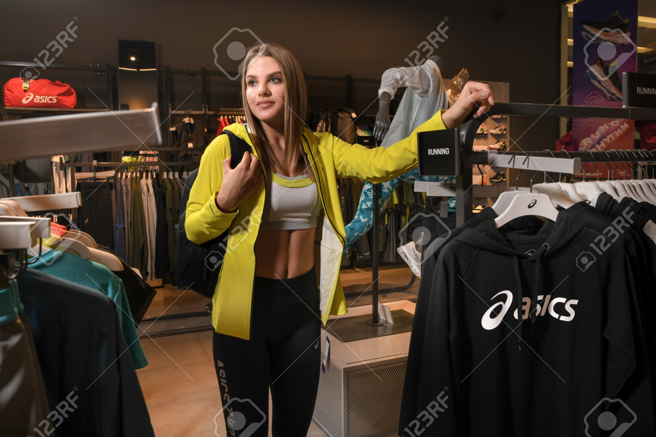 Skopje, North Macedonia - March 12, 2021: Asics store in Skopje, North Macedonia. Girl photo model wearing sports tracksuits and sneakers ASICS GEL, carrying a sports backpack on her shoulder - 166321434 Skopje, North Macedonia - March 12, 2021: Asics store in Skopje, North Macedonia. Girl photo model wearing sports tracksuits and sneakers ASICS GEL, carrying a sports backpack on her shoulder - 166321434