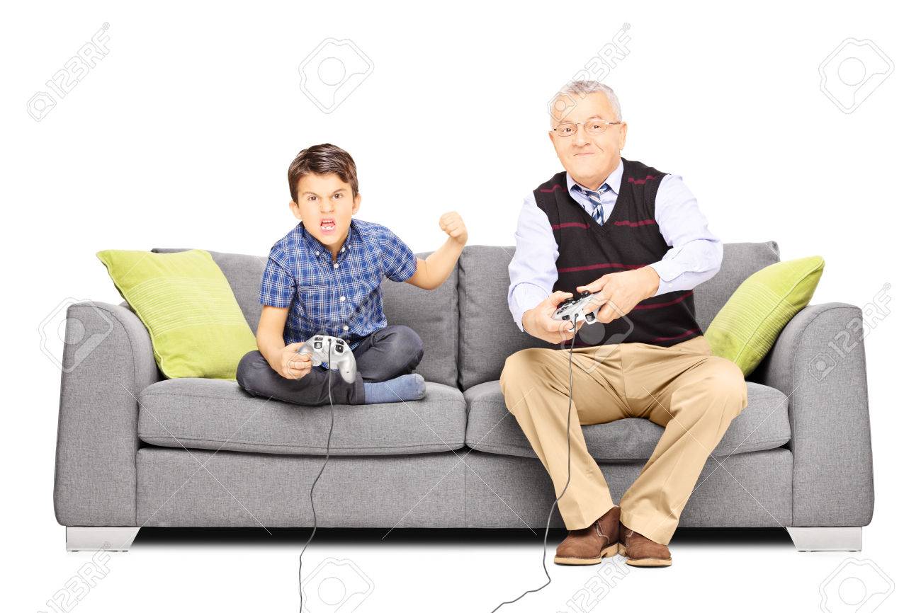 年配の男性がソファに座って 彼の甥は 白い背景で隔離のビデオ ゲームをプレイ の写真素材 画像素材 Image 年配の男性がソファに座って 彼の甥は 白い背景で隔離のビデオ ゲームをプレイ の写真素材 画像素材 Image
