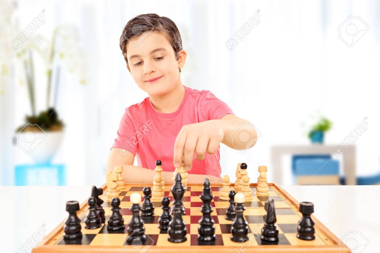 Pupil kid thinking about his next move in a game of chess. Concentrated  little boy sitting at the table and playing chess Stock Photo - Alamy