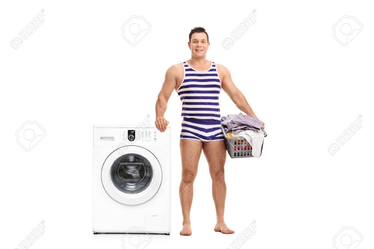 ランドリー バスケットを持って 白い背景で隔離の洗濯機の横に立っているストライプの下着で若い男 の写真素材 画像素材 Image