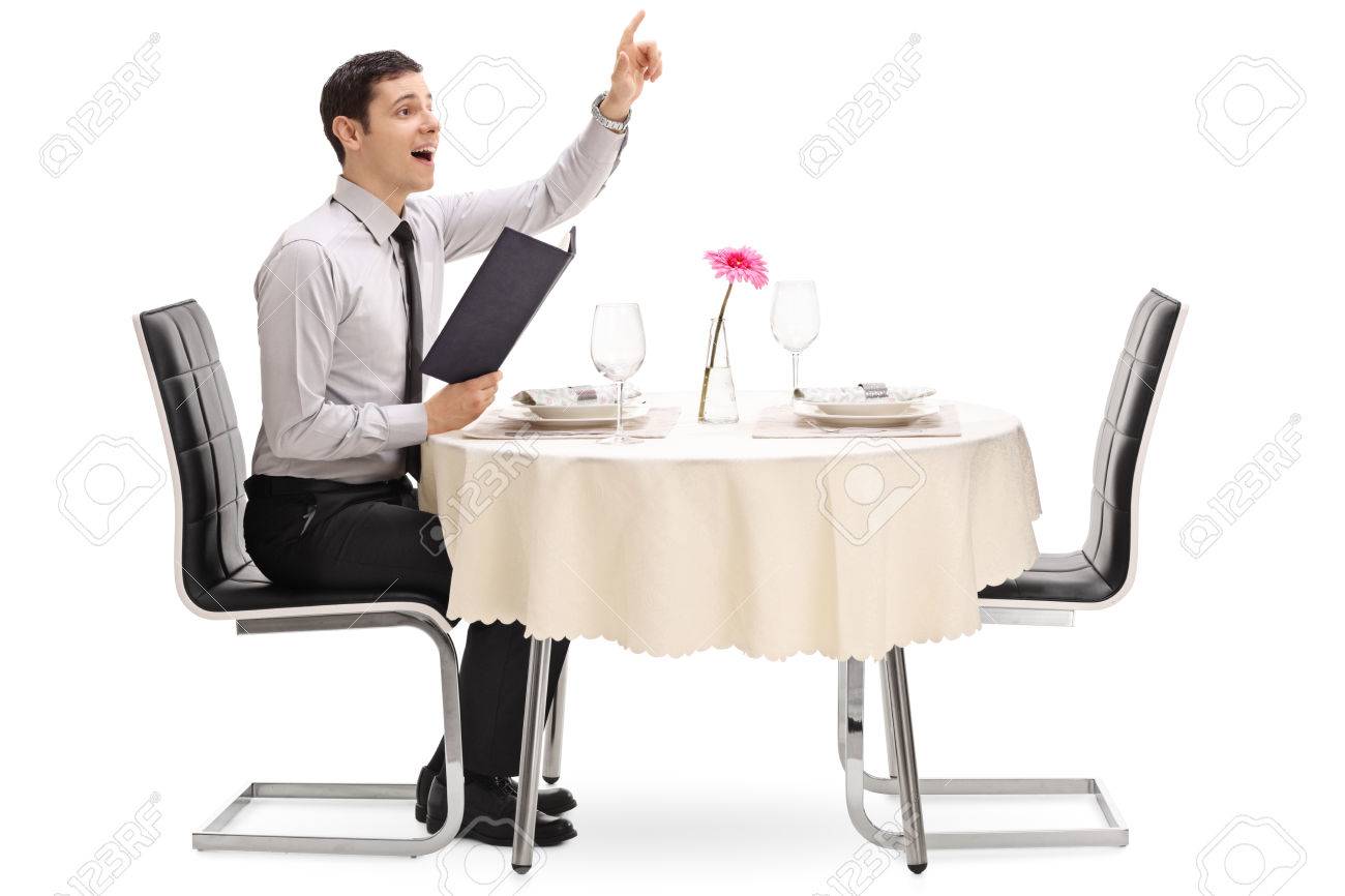 Young man calling the waiter and sitting at a restaurant table isolated on white background - 60812207 Young man calling the waiter and sitting at a restaurant table isolated on white background - 60812207