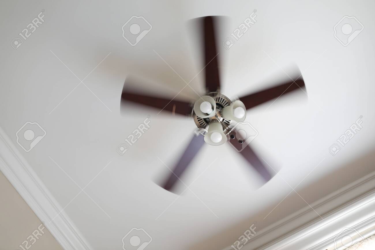 A Working Ceiling Fan On A White Ceiling Close Up With Blurred