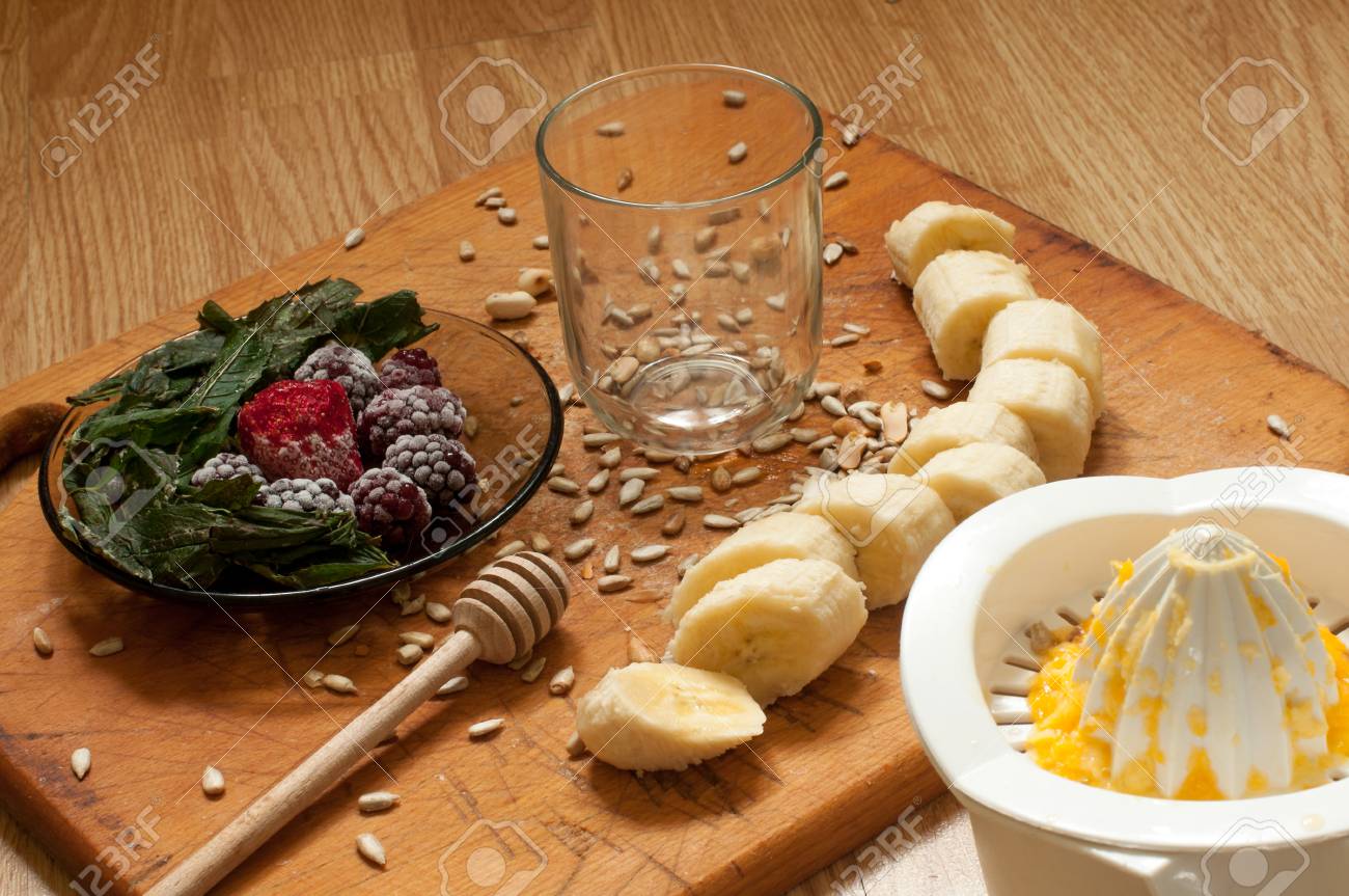 Hand Knijpt Sinaasappelsap Banaan Bevroren Aardbeien Bramen En Zaden Levendige Smoothie Ingredienten En Blender Juicer Tulpen Op De Achtergrond Op Houten Royalty Vrije Foto Plaatjes Beelden En Stock Fotografie Image 76166355