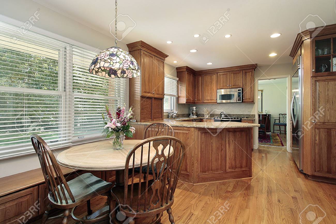 Wood Cabinet Kitchen With Eating Area And Windows Stock Photo