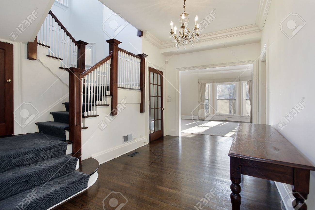 Foyer In Traditional Home With Brown And White Staircase Stock