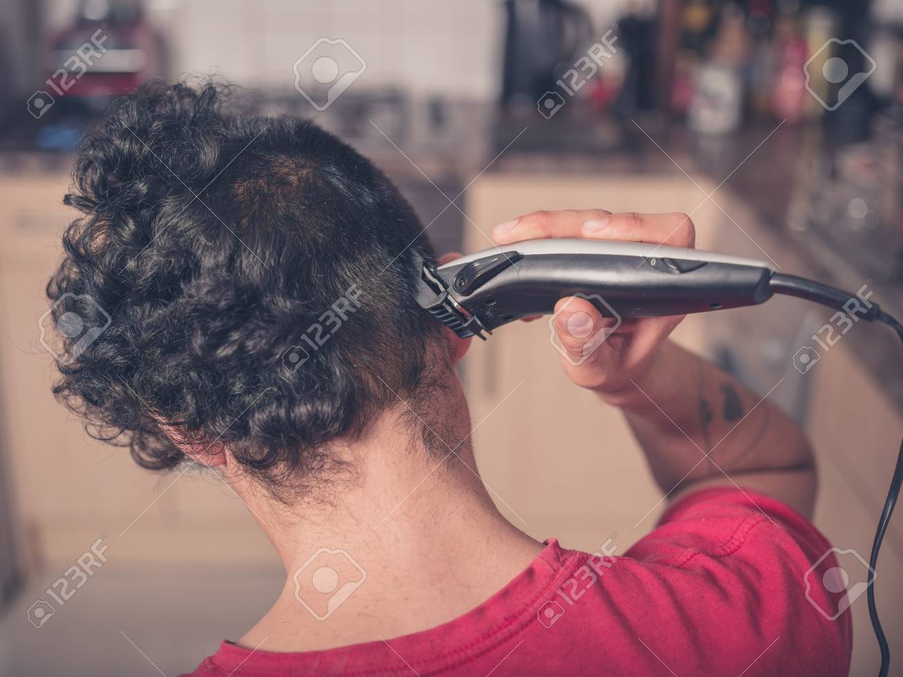 A Young Man Is Using Hair Clippers To Give Himself A Haircut Stock Photo Picture And Royalty Free Image Image 39560342