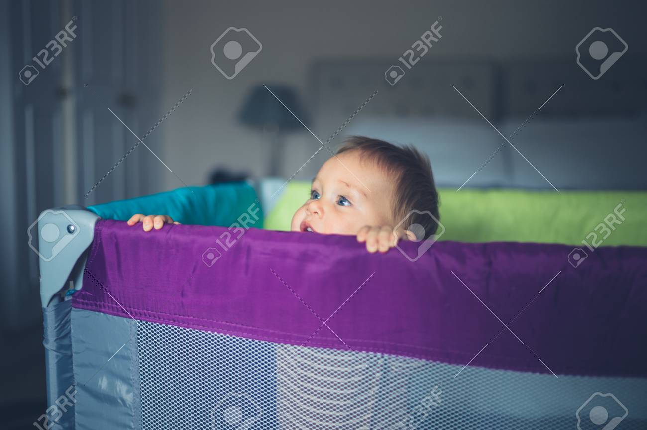 Un Petit Bebe Heureux Se Tient Debout Dans Son Parc Et Regarde De Son Cote Banque D Images Et Photos Libres De Droits Image
