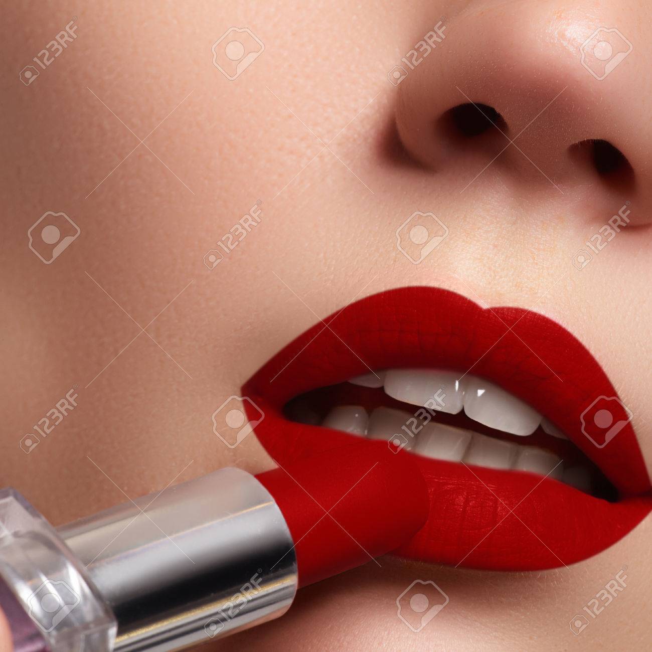 Extreme Close Up On Model Applying Dark Red Lipstick Makeup