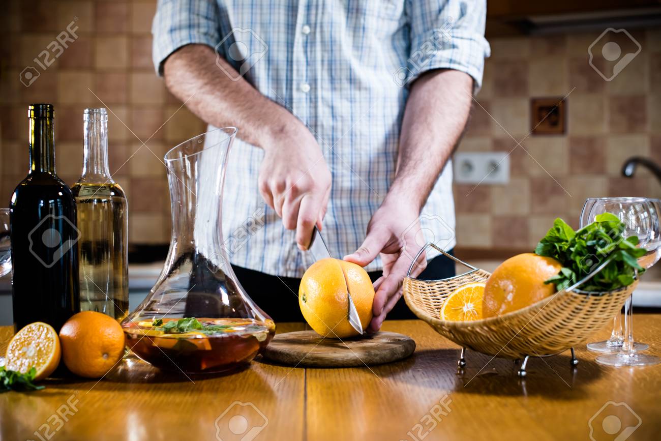 男は ホーム パーティー 自宅のキッチン インテリアのサングリアを作るため新鮮なグレープ フルーツをカットします 自家製の食べ物や飲み物 の写真素材 画像素材 Image