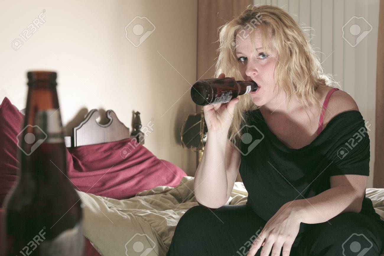 A alcoholic woman drinking beer in his bedroom. - 36919354 A alcoholic woman drinking beer in his bedroom. - 36919354