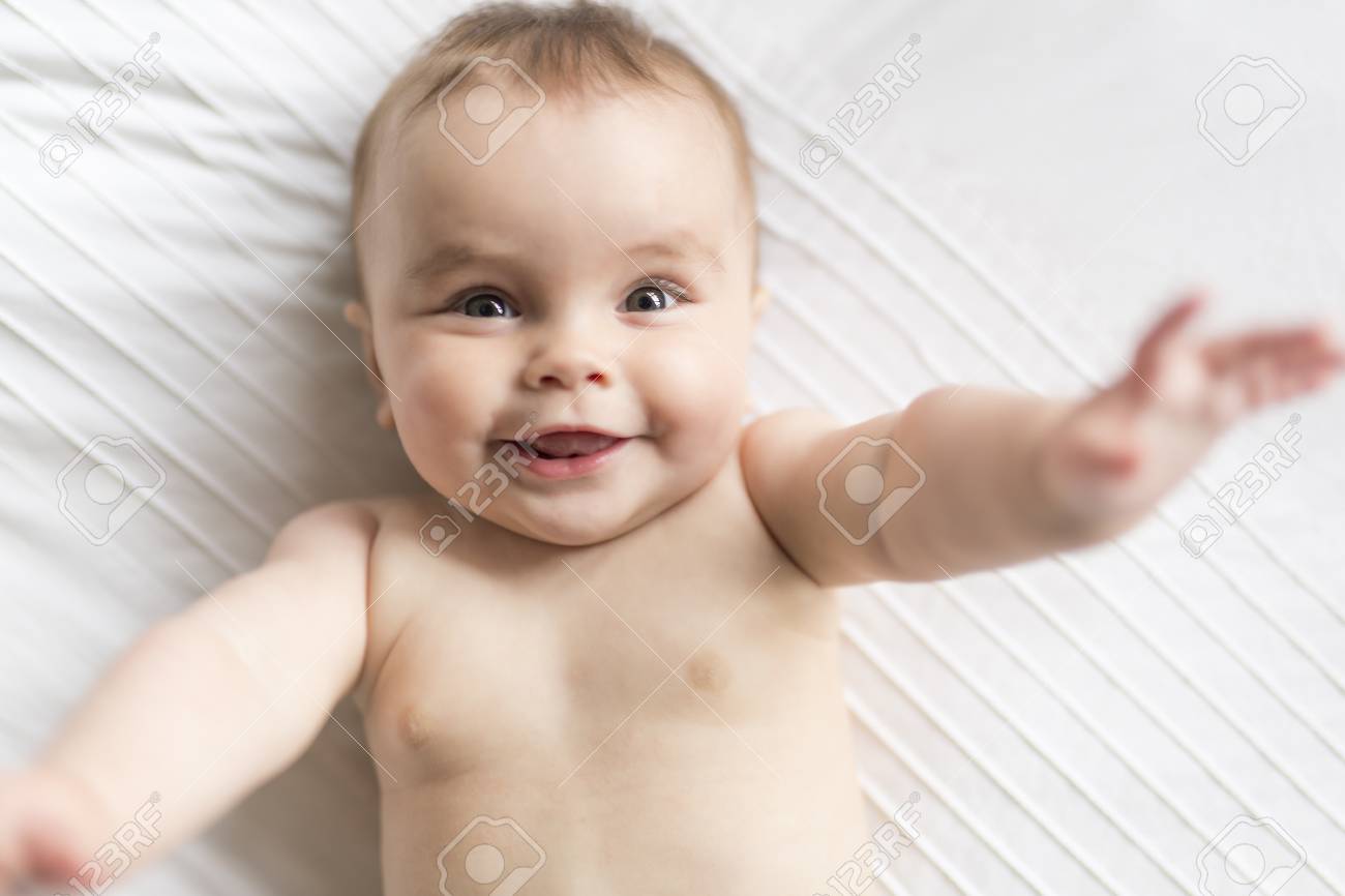 かわいい幸せ7ヶ月おむつに横たわって遊んで赤ちゃんの女の子 の写真素材 画像素材 Image